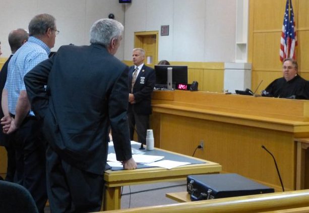 Justice Daniel Billings sentences Robert Welch of Topsham, standing third from left with hands behind his back, to 10 years incarceration and six years of probation, in West Bath District Court on Wednesday. 