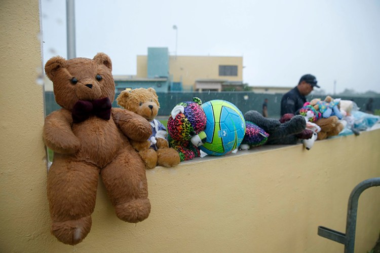 A guard walks by toys placed for the migrant children by protesters as they march to Homestead Temporary Shelter for Unaccompanied Children in Florida in June.