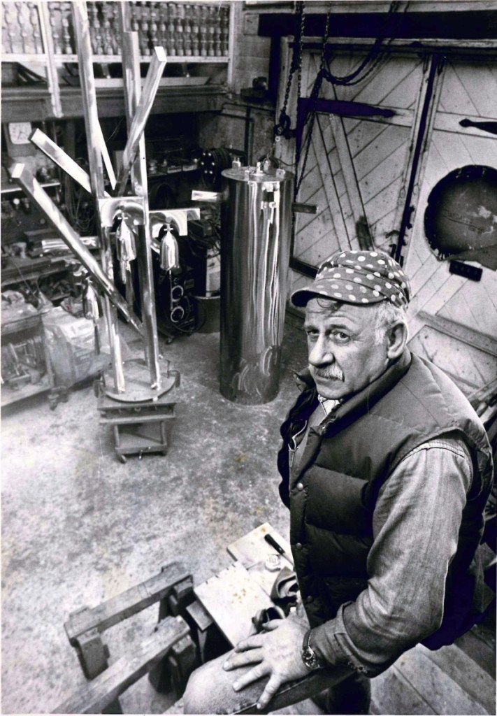 This December 1990 photo shows Roger Majorowicz posing with his sculpture "Macwahoc," which he created for Farmington Elementary School.