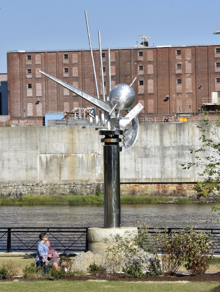 Karla Gerard and Glenn Leavitt pass "The Ticonic" sculpture Sept. 17 at the now open RiverWalk at Head of Falls in Waterville. "This RiverWalk is awesome," Leavitt said. "There is so much history here that it will bring back wonderful memories."