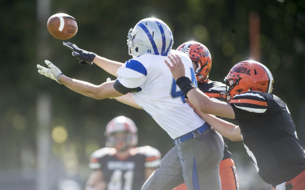 Lawrence tight end Logan Fortin reaches for the pass in front of two Winslow defenders during a game last Saturday in Winslow.