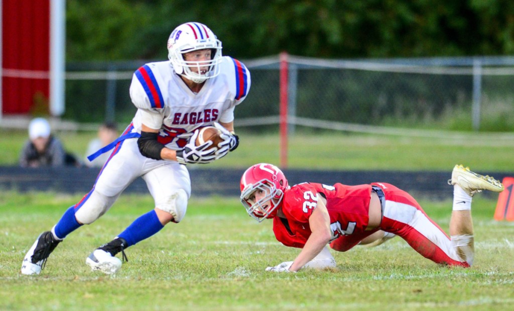 Messalonskee halfback Josh Goff, left, runs around Cony linebacker Mike Wozniak during an August 31 game at Alumni Field in Augusta.