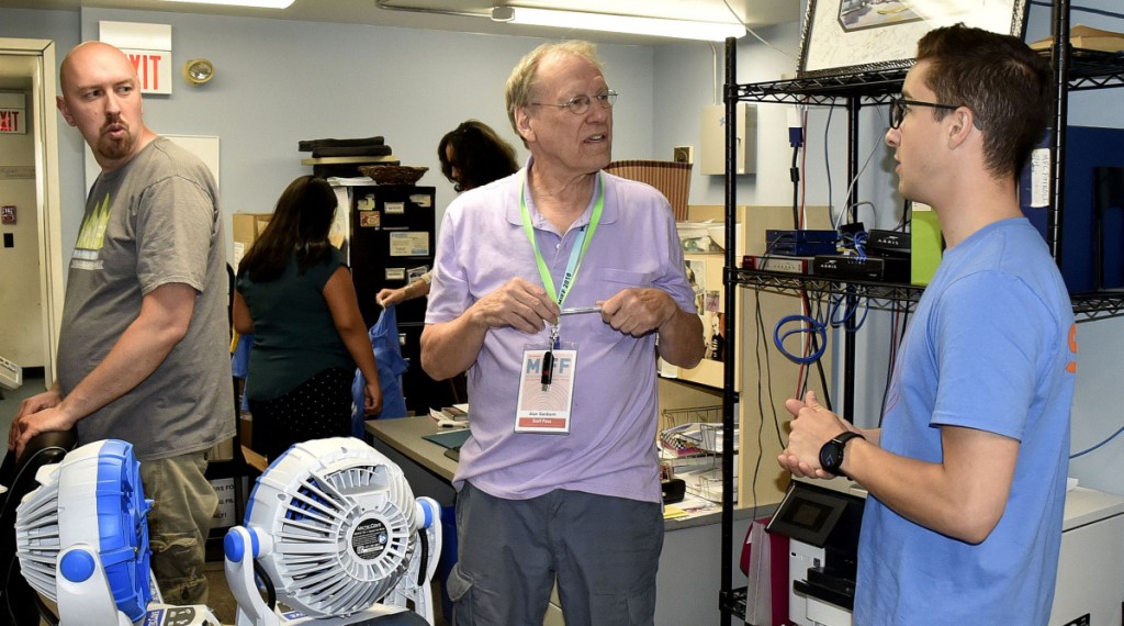 Alan Sanborn, center, one of the original founders of Railroad Square Cinema in 1978, goes over details regarding the 21st Maine International Film Festival with MIFF technician Jason Bailey and Maine Film Center Director Mike Perreault in July.