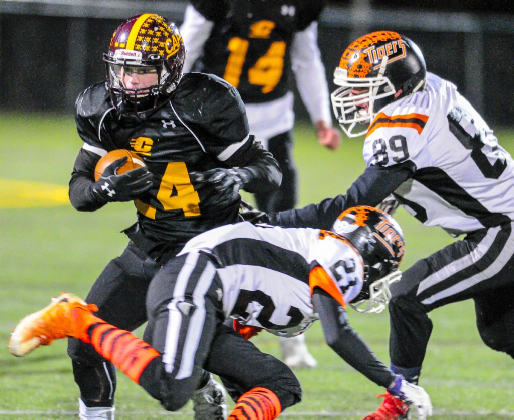 ape Elizabeth's Jack Tower, left, tries to avoid Gardiner defenders Blaise Tripp (21) and Roy Appleby during the Class C South title game last season at Cape Elizabeth.