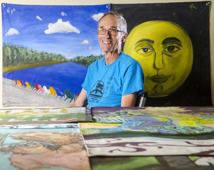 Hallowell Historian Sam Webber talks about the Down with the Crown mural project Thursday at Cox Memorial Methodist in Hallowell. He and his daughter Emily Webber painted the mural of the rainbow chairs, at top left, beside him.