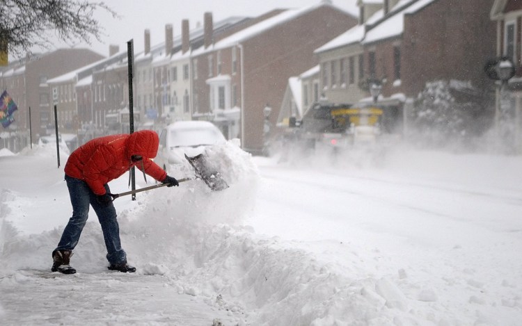 Nathan Sennett shovels snow of the sidewalk in front of his business, Lux, on Dec. 15, 2013, in Hallowell.
