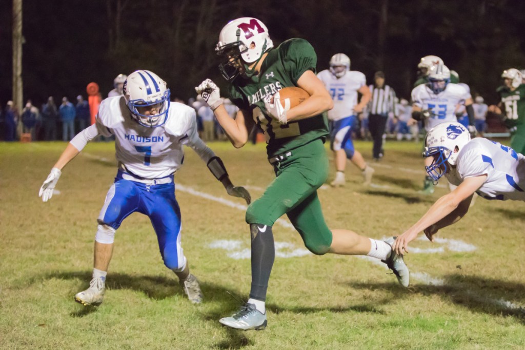 Winthrop/Monmouth/Hall-Dale running back Ian Steele carries the ball as Madison defender Bryce Williette closes in during a game Friday night in Winthrop.