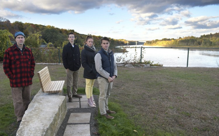 University of Maine at Augusta architecture laboratory supervisor Oliver Solmitz, left, and students, from left, Andrew Treworgy, Shauna Riordan and Sam Gerken, stand on Thursday with the bench they created at Mill Park in Augusta.