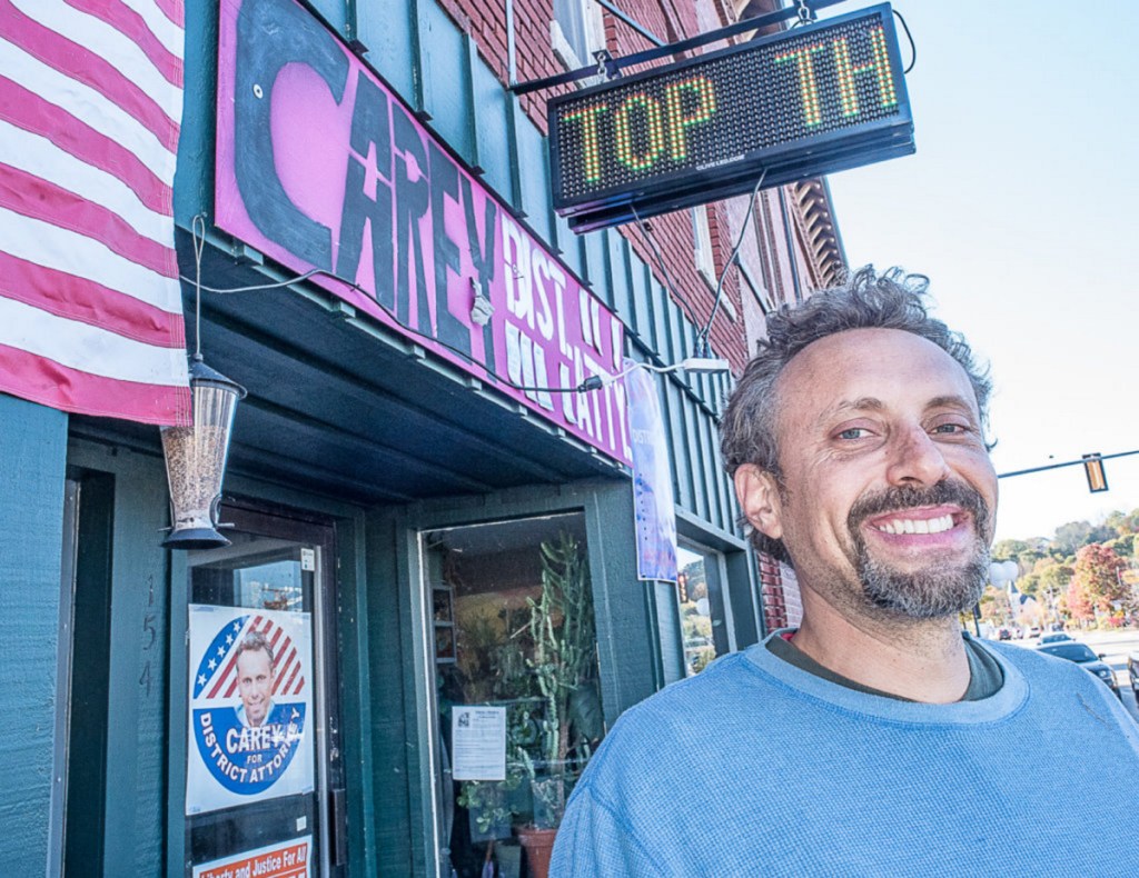 Seth Carey takes a break from painting campaign signs to talk to the Sun Journal outside his office on Court Street in Auburn.