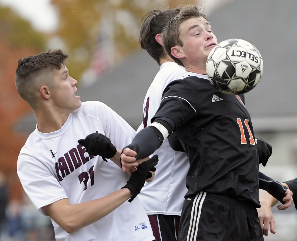 Gardiner's Casey Bourque, right, moves the ball away from Washington's defense during a Class B North quarterfinal game Tuesday in Gardiner.