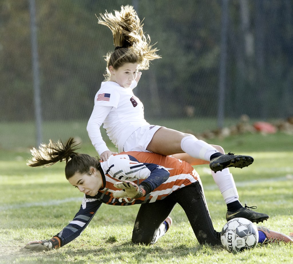 Greely's Logan Pray rolls over Oak Hill goalkeeper Paige Gonya after Gonya made a second in a Class B South quarterfinal game in Wales.