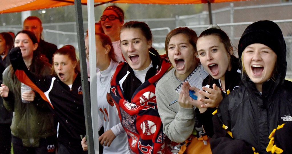 Members of the Winslow girls soccer team applaud after the Black Raiders scored during a Class B North semifinal against Hermon on Monday at Hampden Academy.