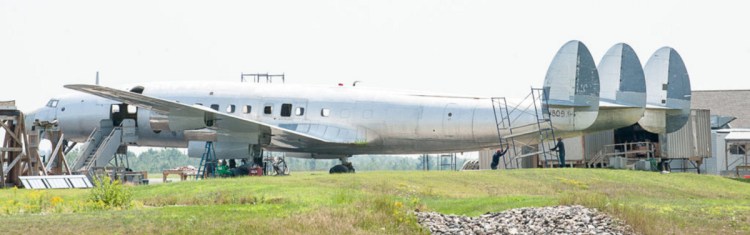 Workers move scaffolding from the triple-tail section of one of the Lockheed Constellations at the Auburn-Lewiston Airport as they continue the process of restoring the exterior to its original markings before being disassembled and moved to JFK airport in New York to be part of a static display at a new hotel. 