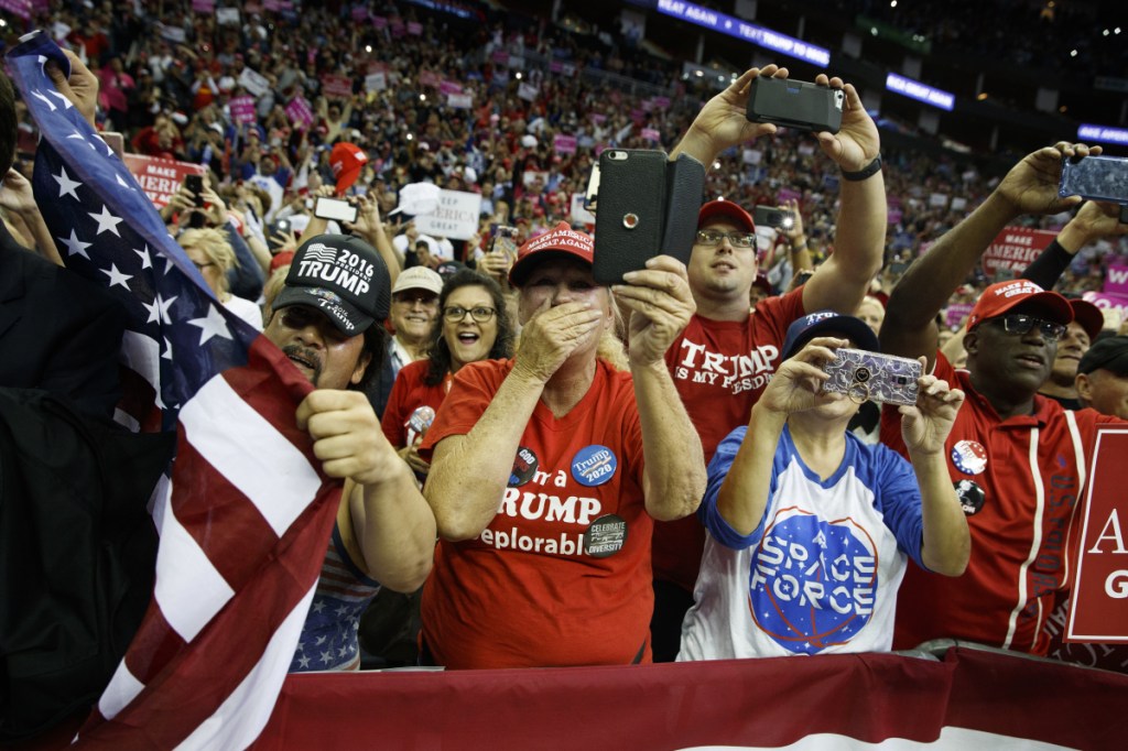 Supporters of President Trump cheer as he arrives for a rally for Sen. Ted Cruz, R-Texas, at Houston Toyota Center on Monday in Houston.