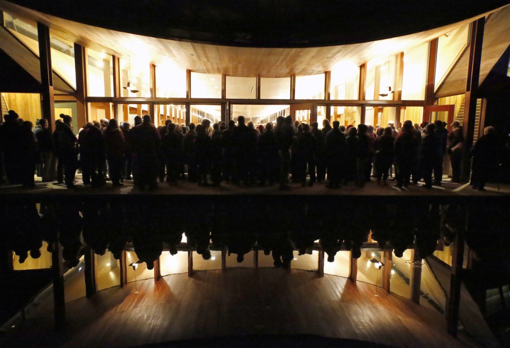 People who couldn’t get into the synagogue listen to the speakers from an outdoor patio area near a reflecting pool. Molly Curren Rowles of the Jewish Community Alliance called the response to the vigil “remarkable.”