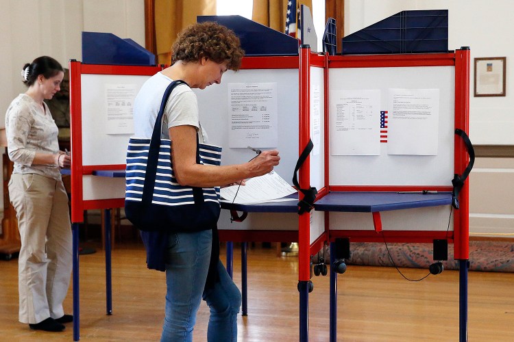 Julie Draper fills out a ballot at Portland City Hall on Oct. 9, the first day of absentee voting. Draper said she'll be away on Nov. 6 and "would never miss voting."