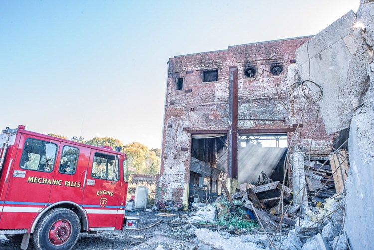 Firefighters remain at the former Marcal Paper mill in Mechanic Falls on Tuesday, as Sunday's fire continues to smolder.