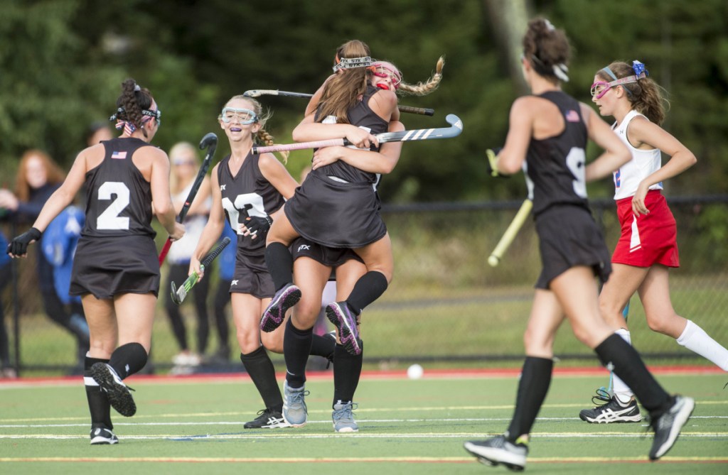 Skowhegan's Alexis Michonski jumps into the arms of teammate Lizzie York after scoring against Messalonskee during a game earlier this season at Thomas College.