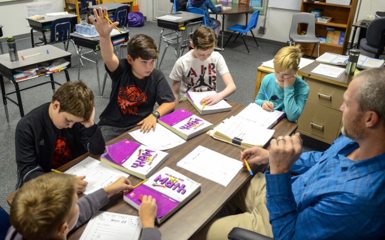 From bottom left, fifth-graders Taisen Pilotte, Alex Reitchel, Wyatt McKenney, Cambell Coutts and Mara Mangin work on mathematics with teacher Adam Hamel on Oct. 18 at Palermo Consolidated School.