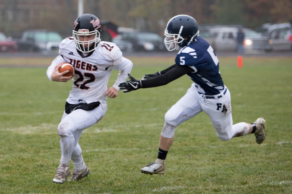 Gardiner's Cameron Michaud (22) carries the ball past Fryeburg's Dawsom Jones in a Class C South semifinal game Saturday at Fryeburg Acedemy.