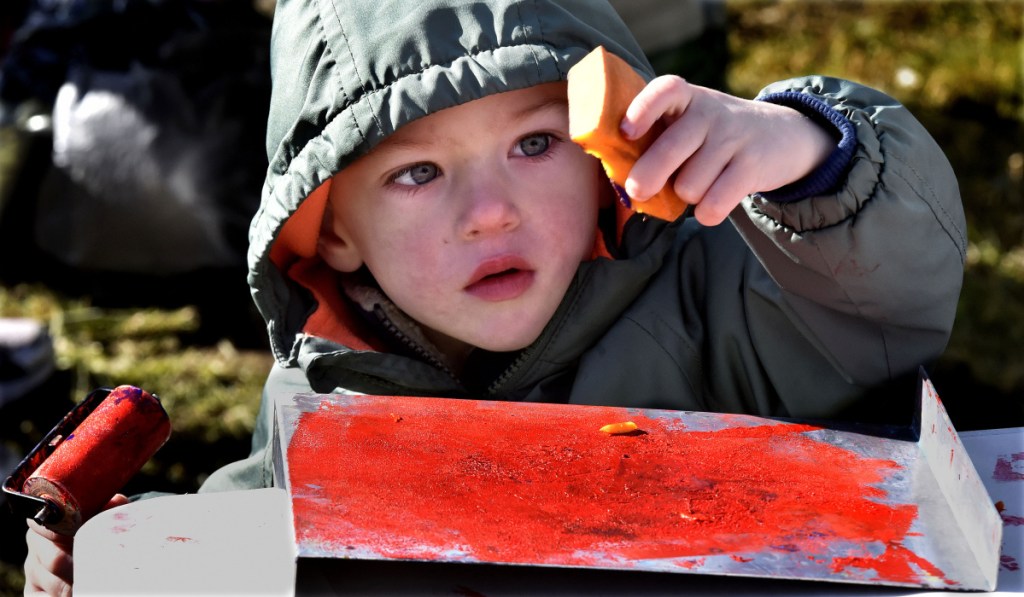 Leo St. Peter IV gets ready to make a stamp out of a carved pumpkin piece on to an inked piece of paper during the Quarry Road Trails Fall Festival in Waterville on Sunday.