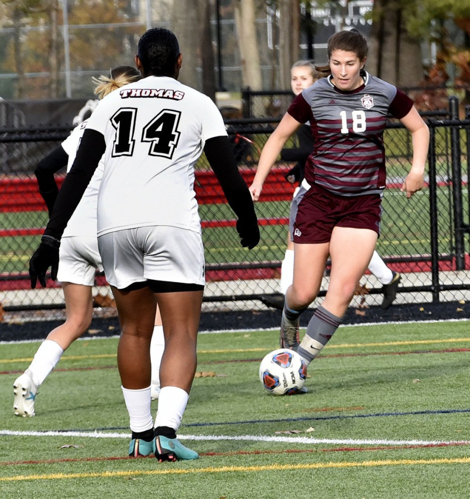 Staff photo by David Leaming 
 UMF's McKenna Brodeur (18) runs with the ball against Thomas in the North Atlantic Conference championship game Sunday in Waterville. Thomas' Taznae Fubler is at left.