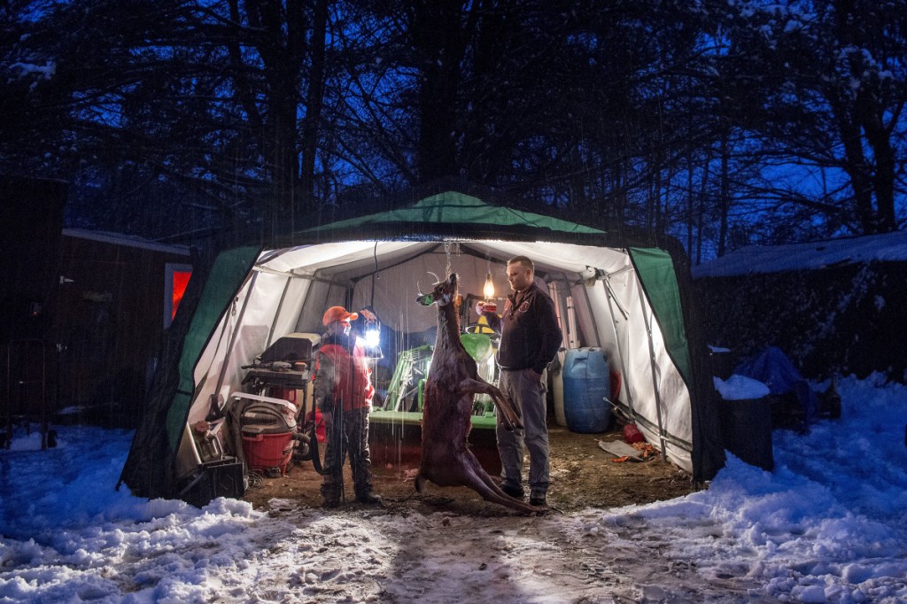 An antler-bearing doe shot by Chase Foss, 9, hangs on Tuesday night outside the Foss family's home in New Sharon. Foss bagged the deer on his first day of hunting on Monday with his father, Daniel Foss, in Solon.