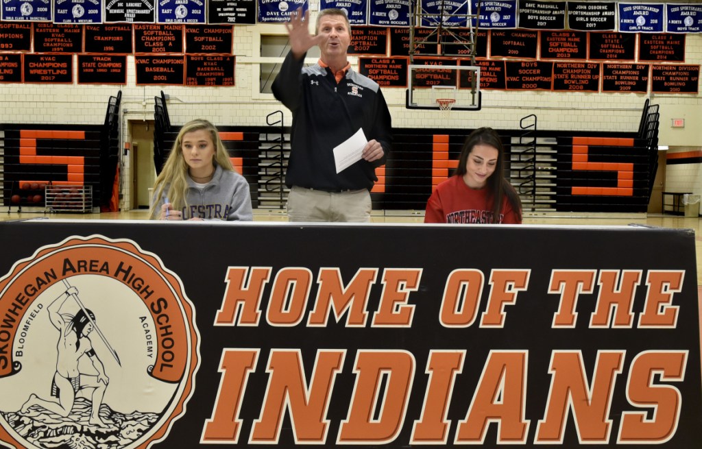 Skowhegan athletic director Jon Christopher, center, praises field hockey players Lizzie York, left, and Maliea Kelso, who signed letters of intent to play for Division I colleges Wednesday in Skowhegan.