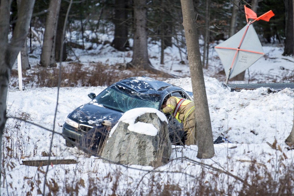 Waterville firefighter Lt. Scott Holst of Engine 2 tends to a car that went off the road near Exit 127 on Interstate 95 southbound in Waterville on Wednesday. The driver's dog ran off after the crash but was found Thanksgiving morning.