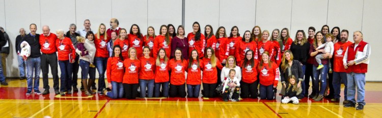 The Burns family poses with previous scholarship winner and other people who've helped run the Chrisanne Burns Tournament on Saturday at Cony High School in Augusta.