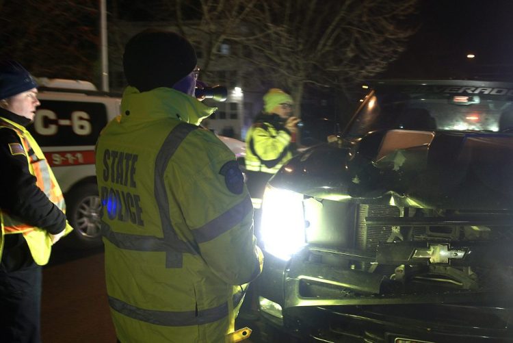 Police examine a damaged pickup truck that hit and killed a pedestrian Monday evening on Memorial Drive in Augusta, near the west end of Memorial Bridge. The victim's identity was being withheld pending notification of his relatives.