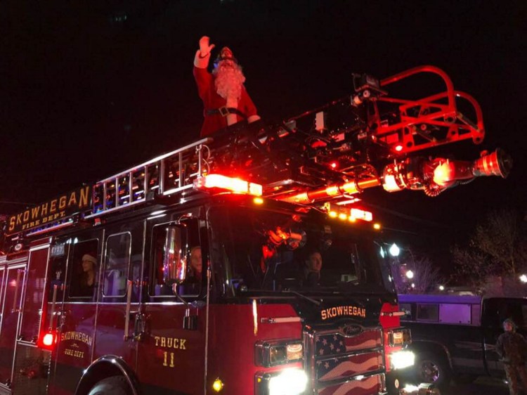 Santa Claus rides high atop a Skowhegan firetruck during the 2017 holiday parade in Skowhegan.
