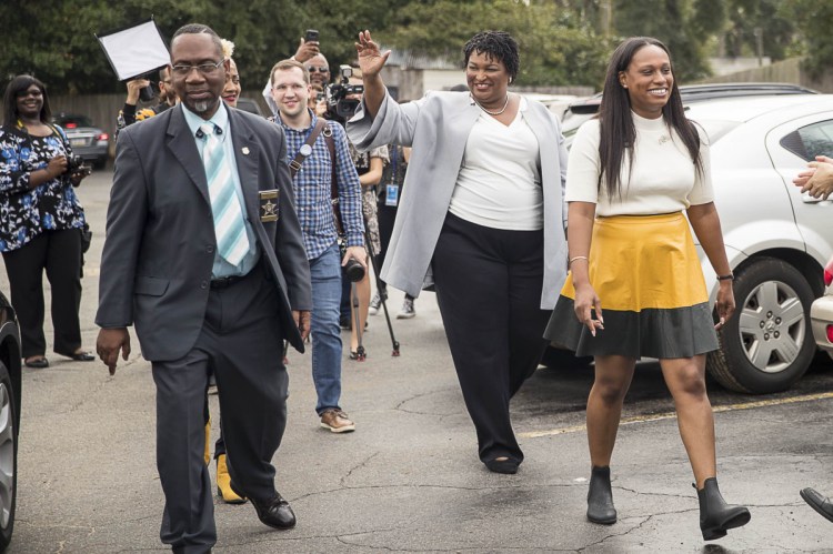 Georgia gubernatorial candidate Stacey Abrams waves at supporters following a campaign stop at Pearly's Famous Country Cooking on Election Day in Albany on Tuesday.