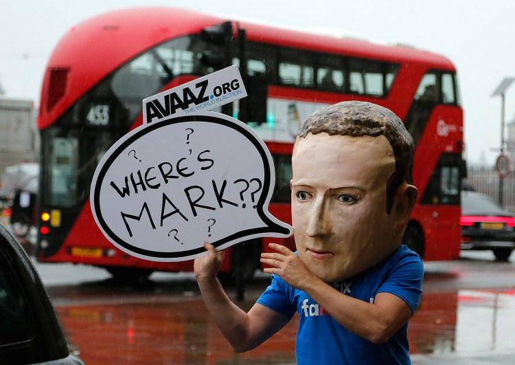 An activist wearing a mask depicting Facebook CEO Mark Zuckerberg stands outside Portcullis House in Westminster as an international committee of parliamentarians met to try to get answers about Facebook's handling of personal data, among other issues, on Tuesday.