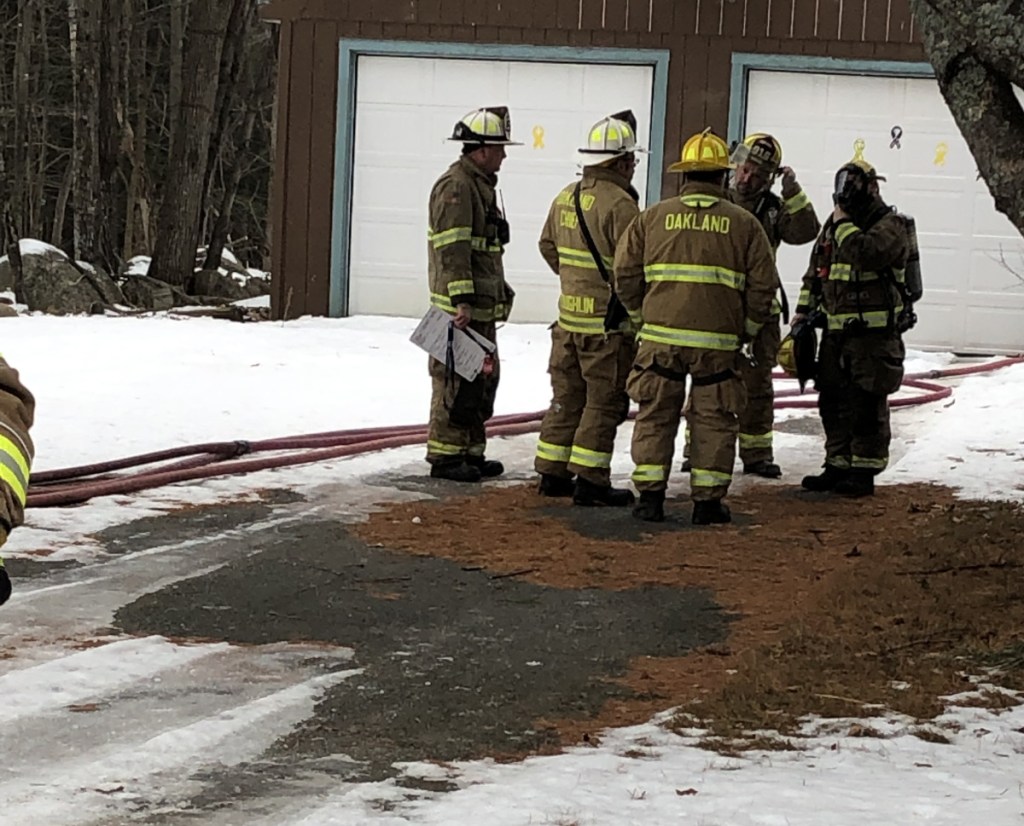 Oakland firefighters huddle on Thursday outside a residence at 25 Denise Ave., where a couple suffered smoke inhalation and minor injuries from a kitchen fire. Firefighters from Oakland, Belgrade, Rome and Sidney responded to reports of the fire, and Waterville firefighters stood by at the Oakland fire station.