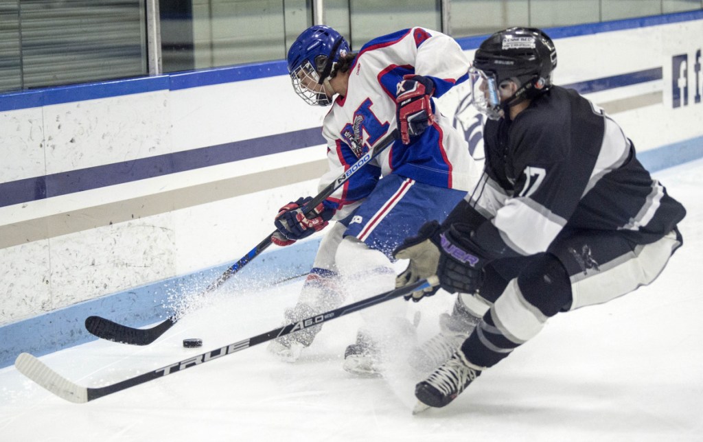 Kennebec RiverHawk forward Cooper Hart, right, battles for the puck with Messalonskee's Sean Rodrigue during the first period of a Class B North game last season at Colby College in Waterville.