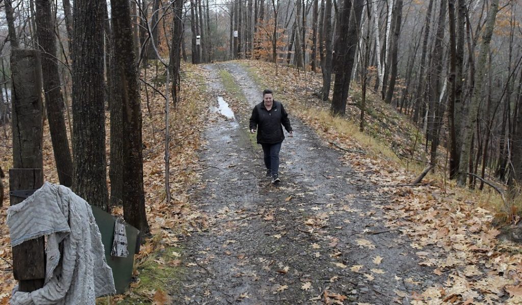 Monique Poulin walks down the road to her home, which faces Boothby Street, on Nov. 13 from pits at the Augusta Public Works facility.