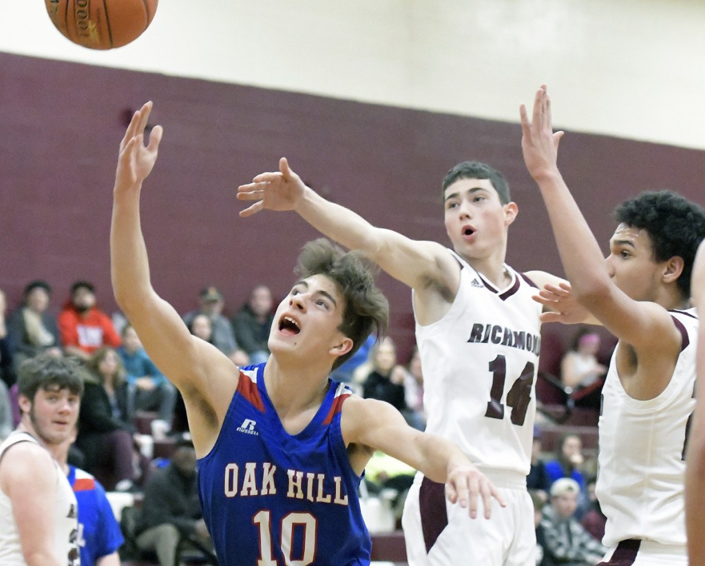Oak Hill's Gabe Samson (10) slides in for two under Richmond defenders during a Mountain Valley Conference game Wednesday in Richmond.
