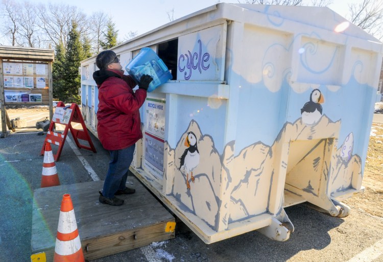 Jeanne Dumont dumps a bin of recyclables into an EcoMaine rolloff container Thursday at the Augusta police station.