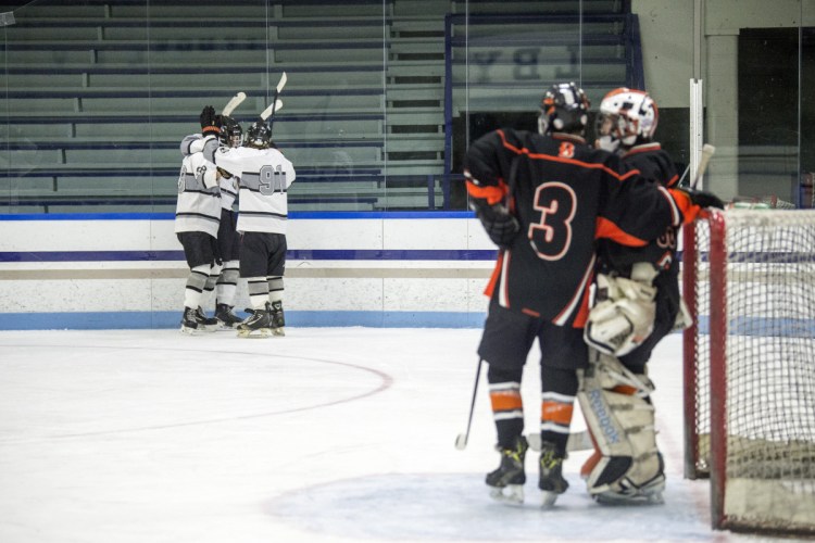 The Kennebec RiverHawks celebrate a goal, left, as Brewer's Aubrey Badger (3) talks to goalie Tyler St. Lawrence in the second period Wednesday at Colby College in Waterville.