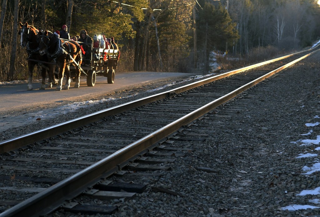 People ride in a sleigh pulled by a pair of Belgian horses belonging to Kenric Charles, of Freedom Township, near the Waterfront Park Gazebo on Sunday in Oakland. The rides were part of a Candleight Christmas Service at the park hosted by the Kingdom Life Church.