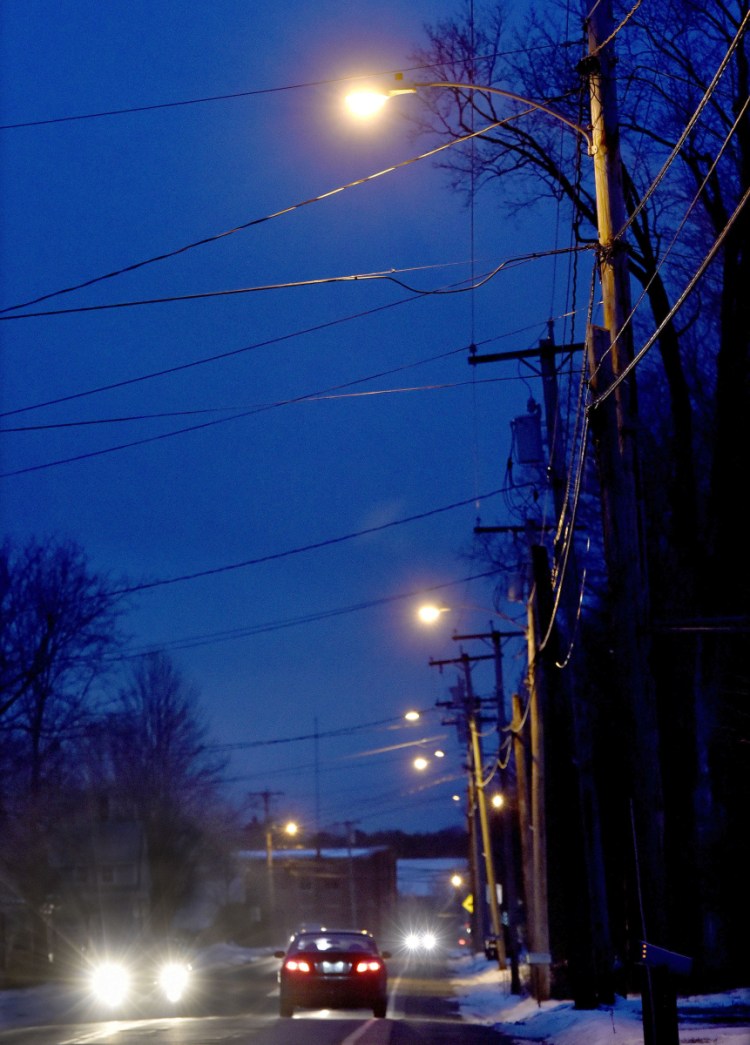 Street lights illuminate Main Street in Vassalboro in late November as traffic passes through town. The town is planning to upgrade lights to LED through Central Maine Power.