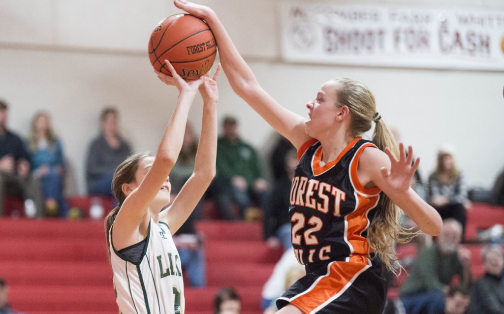 Forest Hills' Taylor Fontaine (22) rejects a shot by Rangeley's Isabelle Whittier (32) on Saturday at Cony High School in Augusta.