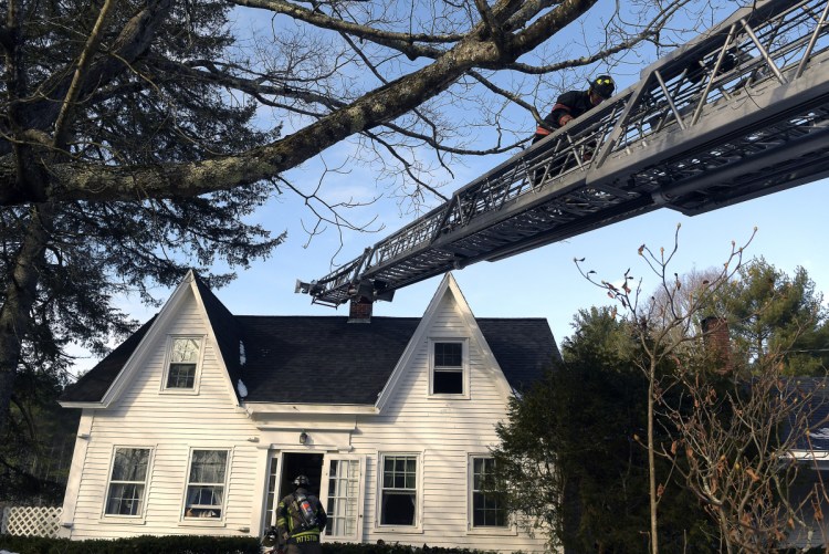 Firefighters extinguish a blaze Monday morning on Neck Road in West Gardiner. Firefighters returned to the farmhouse to discover a fire on the second floor after battling a chimney fire at the residence the night before.