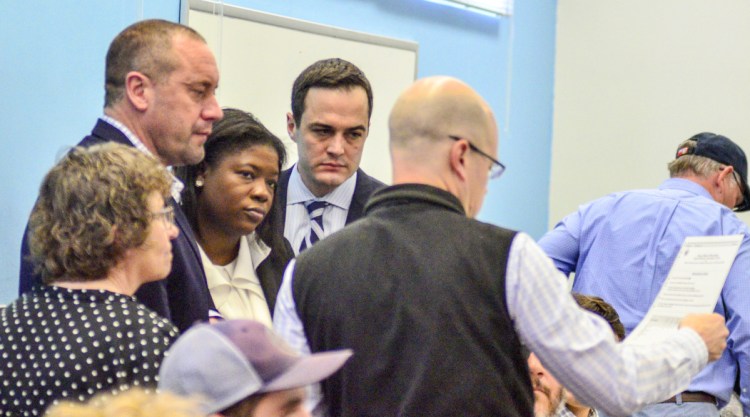 A campaign recount specialist for U.S. Rep. Bruce Poliquin, Kim Pettingill, left, and attorney Josh Tardy, along with U.S. Rep.-elect Jared Golden's campaign attorneys Ruthzee Louijeune, John Giese and Ben Grant, scrutinize a ballot during the recount on Thursday in the Elkins Building in Augusta.