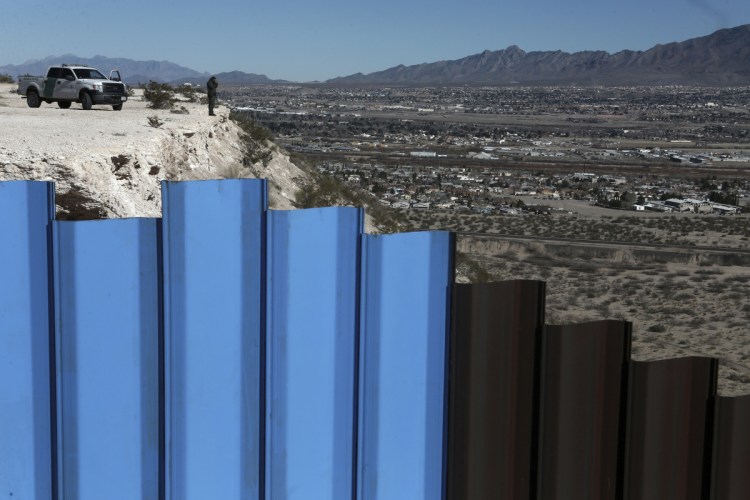 An agent from the border patrol observes near the Mexico-U.S. border fence separating Anapra, Mexico, and Sunland Park, N.M. An 8-year-old boy from Guatemala died in government custody early Christmas Day.