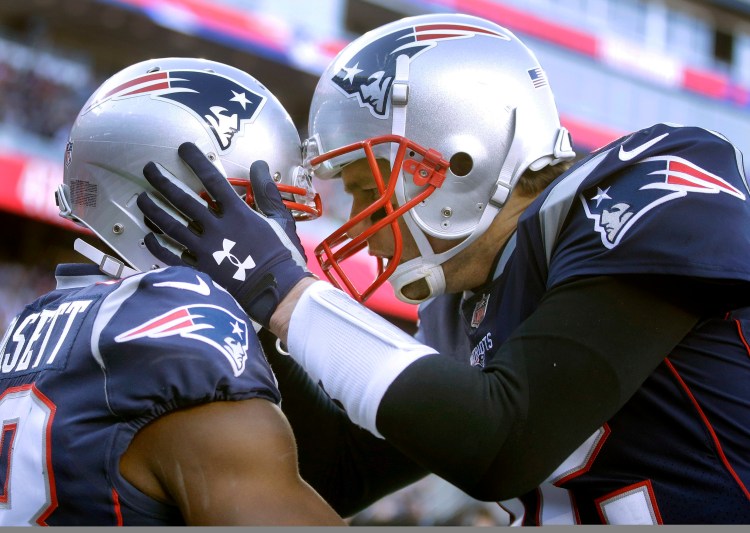 New England Patriots quarterback Tom Brady, right, celebrates his touchdown pass to wide receiver Phillip Dorsett, left, during the first half of the Patriots' 38-3 win Sunday in Foxborough, Mass.
