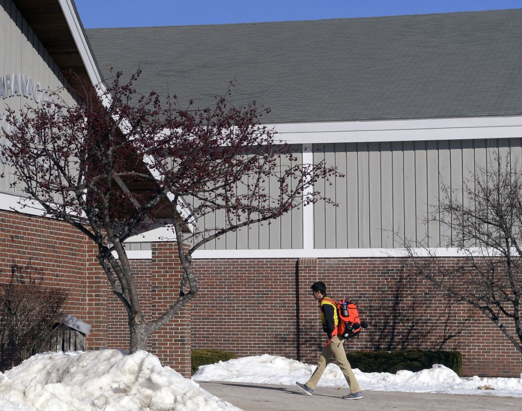 A student enters Maranacook Community High School on Monday in Readfield. Regional School Unit 38 voters have approved a bond to put a new roof on the school, among several facility projects.