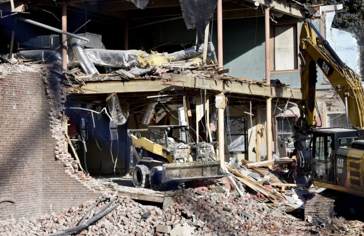 An equipment operator works on Tuesday in a section of the former Camden National Bank on Main Street in Waterville, which is being demolished to make way for a boutique hotel owned by an affiliate of Colby College.