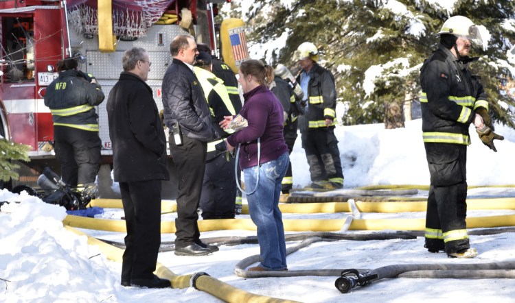 Homeowner Tracy Moody speaks with friend Larry Jones, left, and Skowhegan Fire Chief Shawn Howard as firefighters extinguish a fire that destroyed her mobile home Wednesday in Norridgewock. The state fire marshal's office has determined that a malfunction in the mobile home's electrical system started the fire.